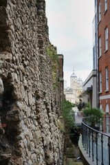 Fototapeta na wymiar Historic cobblestone walls of the City of London, with the iconic Tower of London visible in the background 