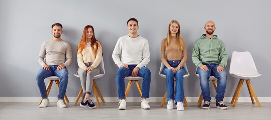 Group portrait of young smart people chair sitting in easy pose, one vacant place left. Diverse new...