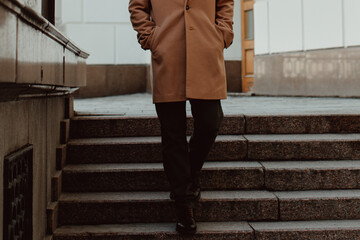 Man walking alone in the city, fashion details of beige brown men's coat and black turtleneck. Classic street outerwear