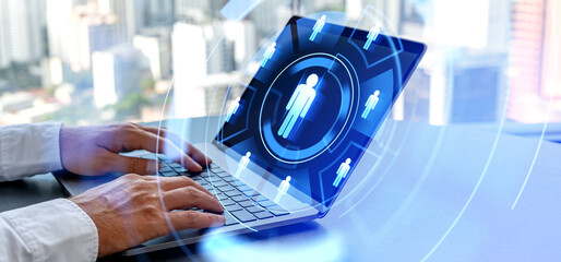 Fototapeta premium Man hands typing in laptop computer, human resourcse icons in glowing circle