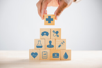 Captured moment, Hand gripping a wooden block showcasing healthcare and medical icons. Depicting safety, health, and family care, symbolizing pharmacy and heart well-being. health care concept