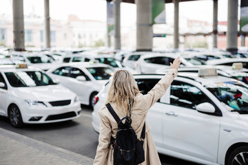 Woman with backpack calling taxi at train station