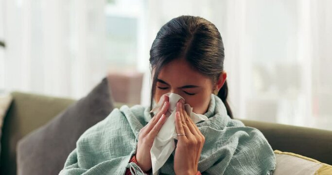 Woman, sick and tissue with blowing nose in home for respiratory influence, illness or cold. Female person, blanket and fever flu or virus suffering in living room with allergies, sneezing or fatigue