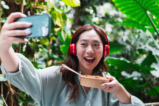 Happy woman taking selfie with food container
