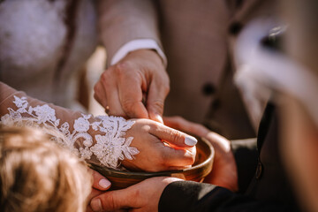Valmiera, Latvia - Augist 13, 2023 - Hands reaching into a bowl, with one person wearing a lace...