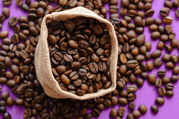 coffee beans  in burlap bag on the background, coffee beans in a burlap bag on the purple background with a place for inscription. on coffee beans background