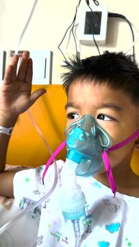 Asian little kind boy is patient by inhalation therapy  with oxygen mask breathes through nebulizer at hospital. kid with RSV ,Respiratory Syncytial Virus, problem