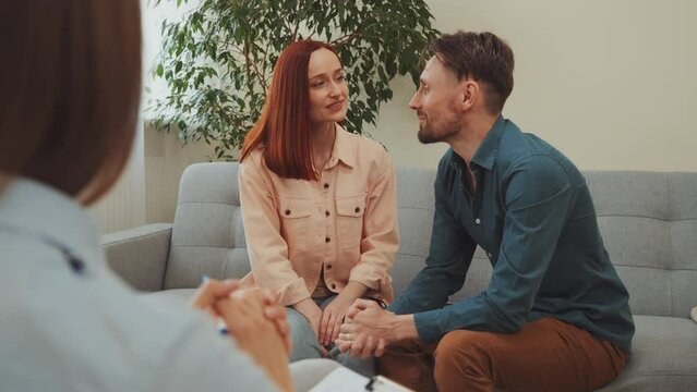 Couple holding hands, smiling and embracing each other during therapy session, significant step towards reconciliation, closeness and understanding