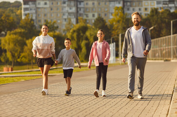 Happy sporty active family in sportswear walking together, enjoy good weather outdoor exercising...