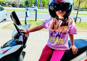 Adorable little girl having fun on her motorcycle
