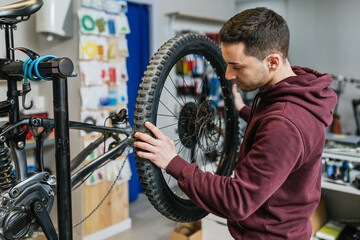 Bike mechanic changing and examining a mountain bike wheel.