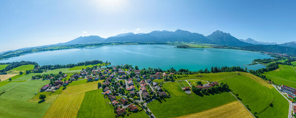 Sommerlicher Ausblick auf die Gemeinde Rieden und den Forggensee am Alpenrand im Allgäu