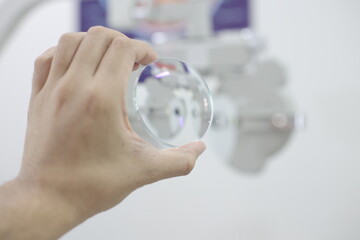 hand holding glasses lenses on grey background 