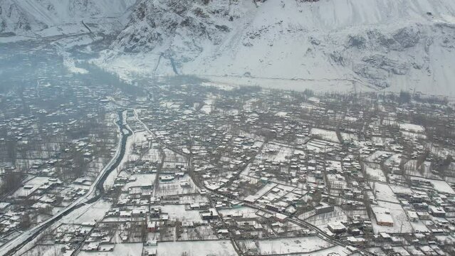 Panning drone view of snow covered crowded Skardu city, Pakistan.
