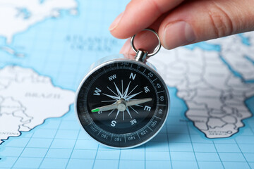 Compass on the background of the world map.