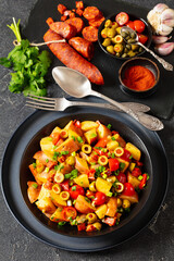 spanish potato salad with chorizo in black bowl
