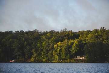 Scenic view of McClaine lake in Hayward, Wisconsin with green forest and a cabin in it