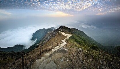 Narrow walkway on top of the big mountains with the clouds in the background