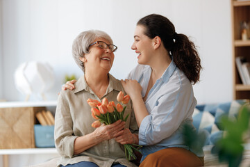 woman and her mother with flowers tulips - 779552781