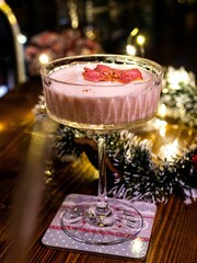 Vertical shot of a pink cocktail with rose