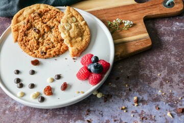 Closeup shot of a plate with freshly baked cookies and berries on a wooden table