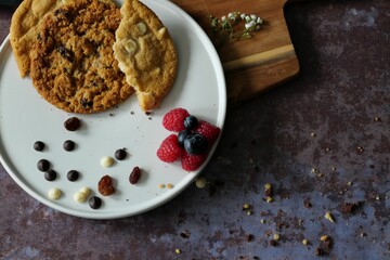 Closeup shot of a plate with freshly baked cookies and berries on a wooden table