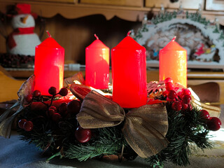 advent wreath decorated with red candles at the table
