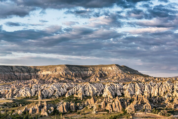 Cappadocia at sunset. Landscape of Goreme valley with blue sky and scenic clouds at background. Nevsehir, Turkey (Turkiye)