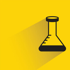 science flask with shadow on yellow background