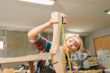 In a bustling carpenter's shop, a young woman craftsman expertly navigates her workshop, merging...