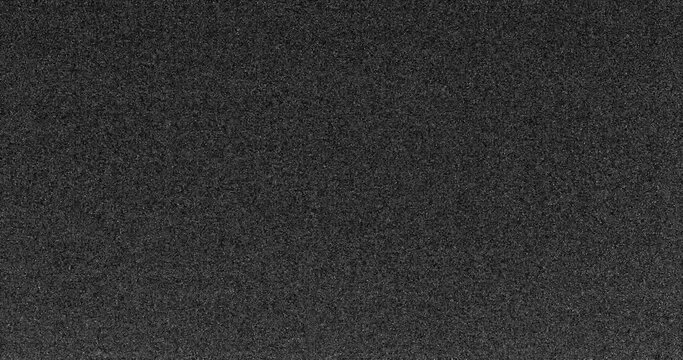 digital noise A close up of a white and gray noise with a grainy texture. The pattern of tints and shades create a contrast with the dark background, giving it a peach and carmine undertone. TV