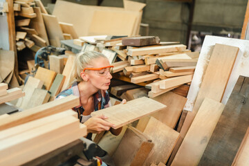 In a bustling carpenter's shop, a young woman craftsman expertly navigates her workshop, merging...