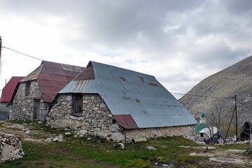 Closeup shot of old houses made of stones and rusty metal roofs in a countryside
