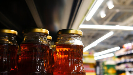 Close-up of many glass bottles of apple juice on a store shelf