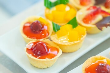 Closeup shot of tasty and sweet tartlets with fruits put on the white plate