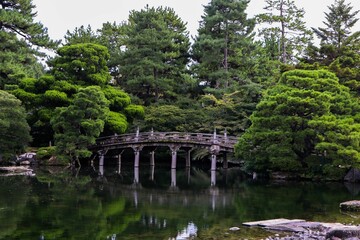 Fototapeta na wymiar Bridge over a lake in Imperial Palace surrounded by trees in Kyoto, Japan