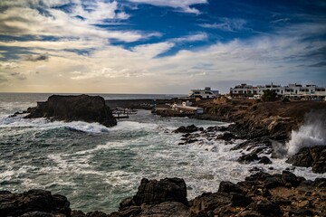 Mesmerizing shot of the waves hitting the volcanic rocky shore on Fuerteventura island in Spain