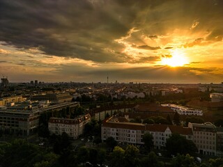 Obraz premium Bright sun shining behind sunset clouds over Berlin cityscape