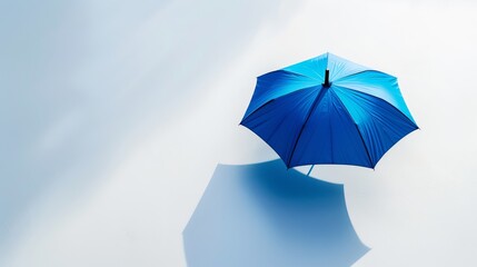 A modern blue umbrella, showcased in isolation on a white background with a shadow, emphasizing its sleek design and utility