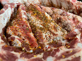 Obraz premium Full-frame shot of raw pork ribs on a black plate