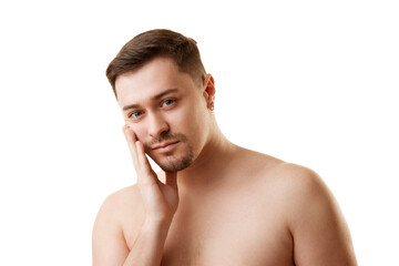 Portrait of shirtless bearded young handsome man looking at camera and touching his face against white studio background. Concept of natural beauty, male health, anti-aging, spa procedures, cosmetic.