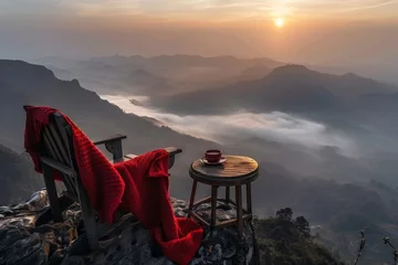 Deurstickers Sunrise over a misty mountain valley with chair. A serene sunrise scene over a fog-covered mountain valley with a red chair in the forefront © Vuk