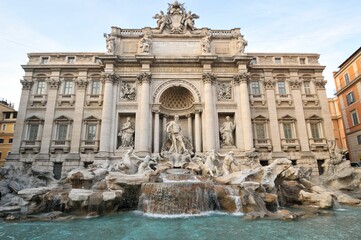 Trevi Fountain and building facade exterior with columns and pediment in Rome, Italy