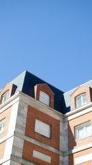 Low-angle shot of a colorful building with geometric patterns under clear blue sky
