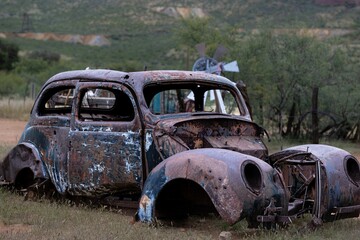 Fototapeta premium Vintage rusty old abandoned car decaying on a rural field