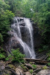 Obraz premium Small waterfall on rocks surrounded by greenery in a forest in the daylight