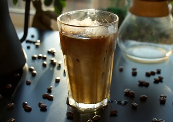 Closeup of an iced coffee in a glass decorated with coffee beans in a cafe