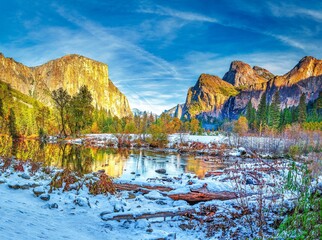 Frozen lake with rocky mountains and blue cloudy sky in Yosemite National Park during winter