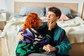 young joyous couple in vibrant clothing spending time together and hugging each other lovingly
