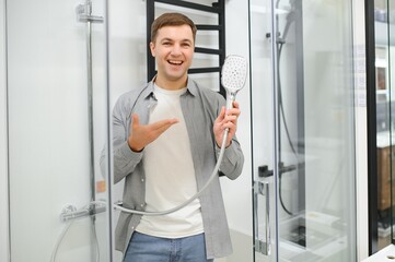 man choosing shower cabin and utensils for his home bathroom